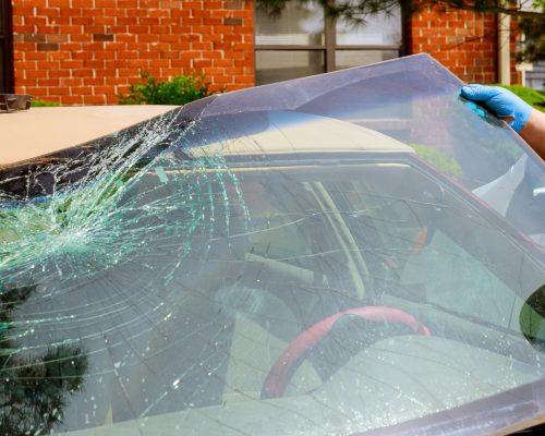 workers-remove-crashed-windshield-of-a-car-in-auto-oudoors-service.jpg